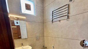 Un baño con inodoro, lavabo y ducha.
