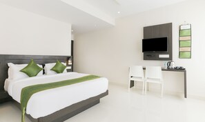 Une chambre d’hôtel moderne équipée d’un grand lit, d’un bureau et d’un téléviseur à écran plat.