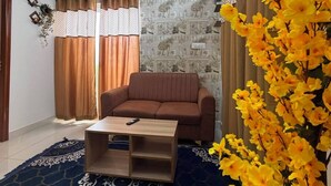 Ein Wohnzimmer mit einer Couch, einem Couchtisch und einem gemusterten Teppich.