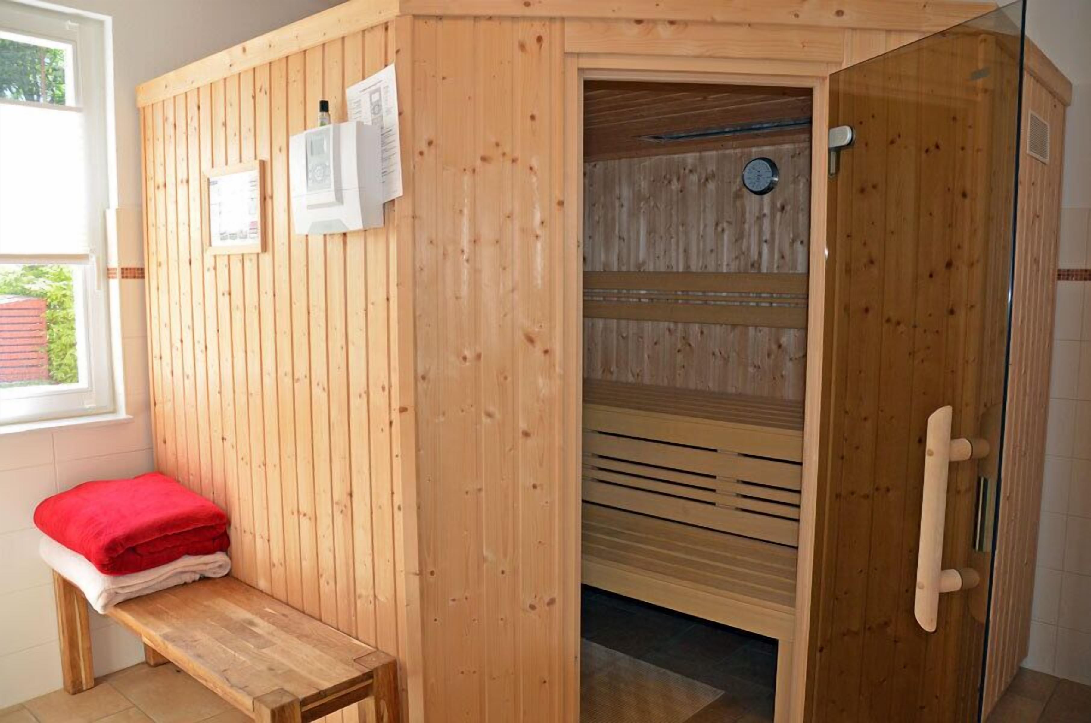 Un sauna avec des murs en bois, un banc et une porte.