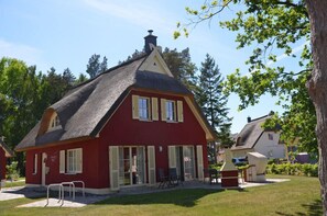 A red building with a thatched roof, a small porch, and a chimney. - Vacation home with a fireplace and sauna, about 500 meters from the sandy beach, 4 bedrooms, Wi-Fi (Glowe)