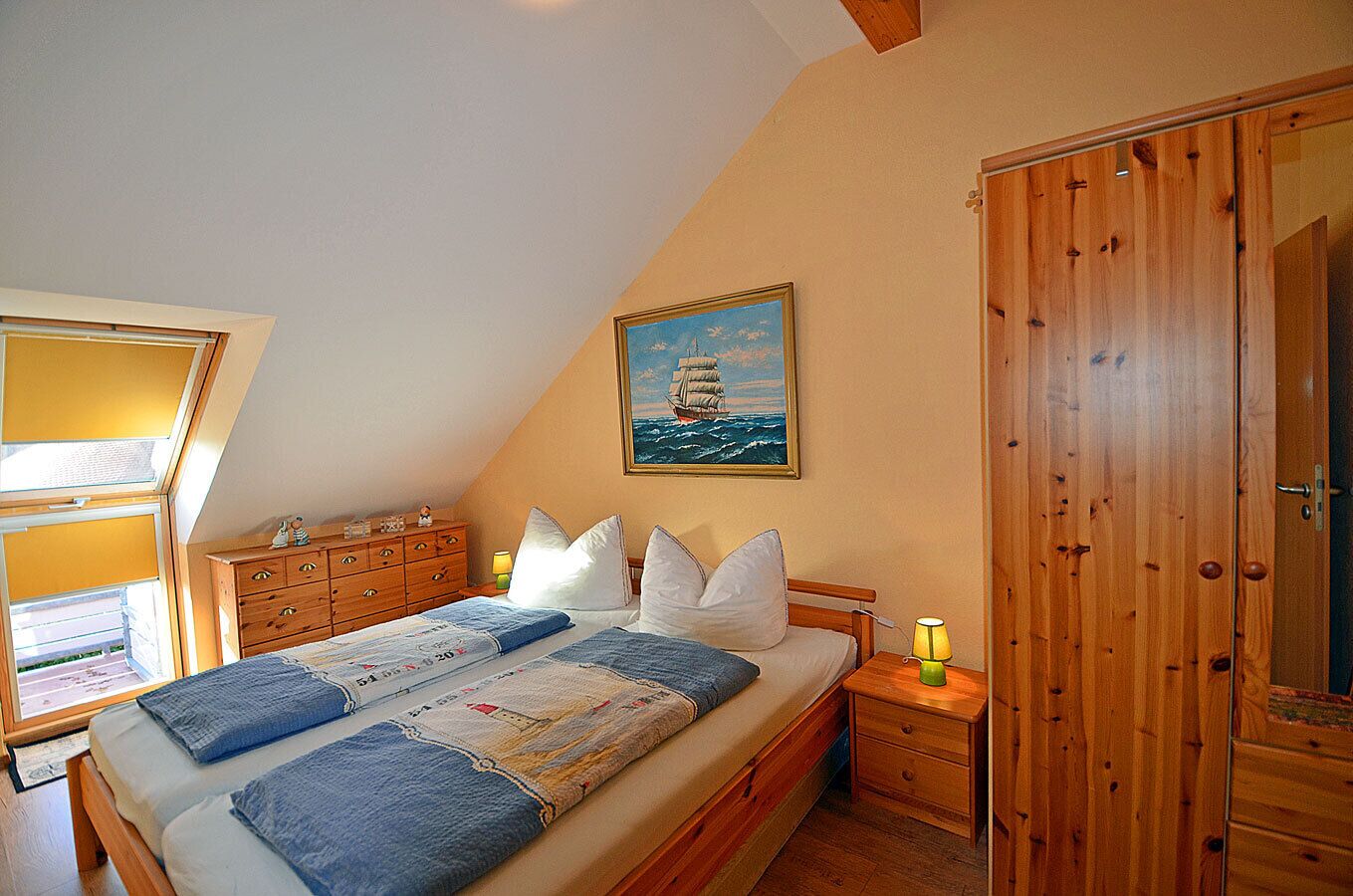 A bedroom with a bed, a dresser, a nightstand, a painting, and a wooden wardrobe.