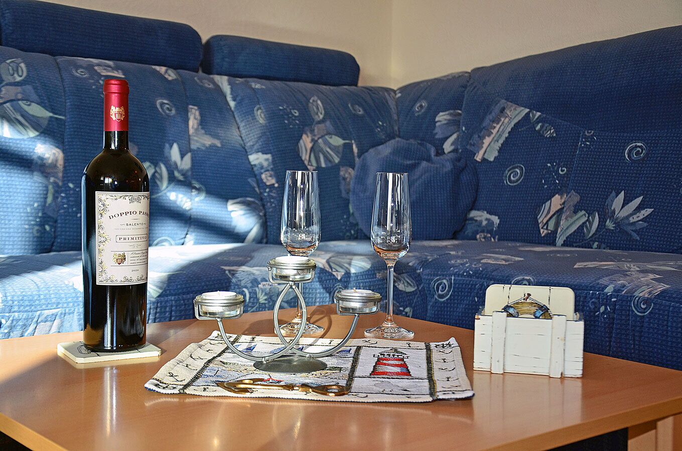 A table with a bottle of wine, two glasses, and a candle holder.