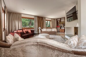 A living room with a large sectional sofa, a smaller sofa, a coffee table, and a bookshelf. - Charming Lake Front Villa Beatrice in Mandello del Lario (Mandello del Lario)