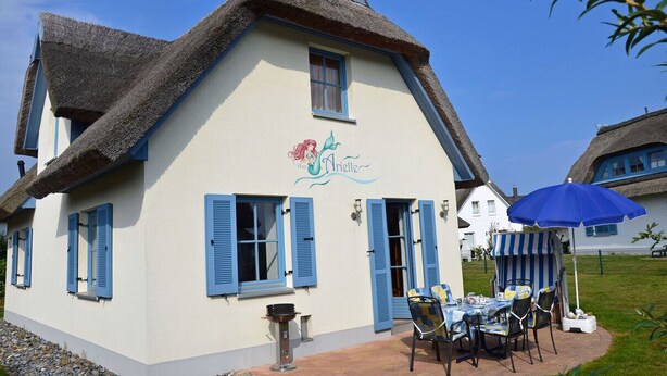 A traditional building with a thatched roof, a sign reading 'Hôtel Arielle,' and a table with chairs outside. - Vacation home with a fireplace, about 400 meters from the sandy beach, Wi-Fi, dogs welcome (Glowe)