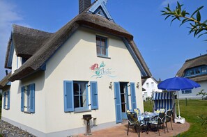 A traditional building with a thatched roof, a sign reading 'Hôtel Arielle,' and a table with chairs outside. - Vacation home with a fireplace, about 400 meters from the sandy beach, Wi-Fi, dogs welcome (Glowe)
