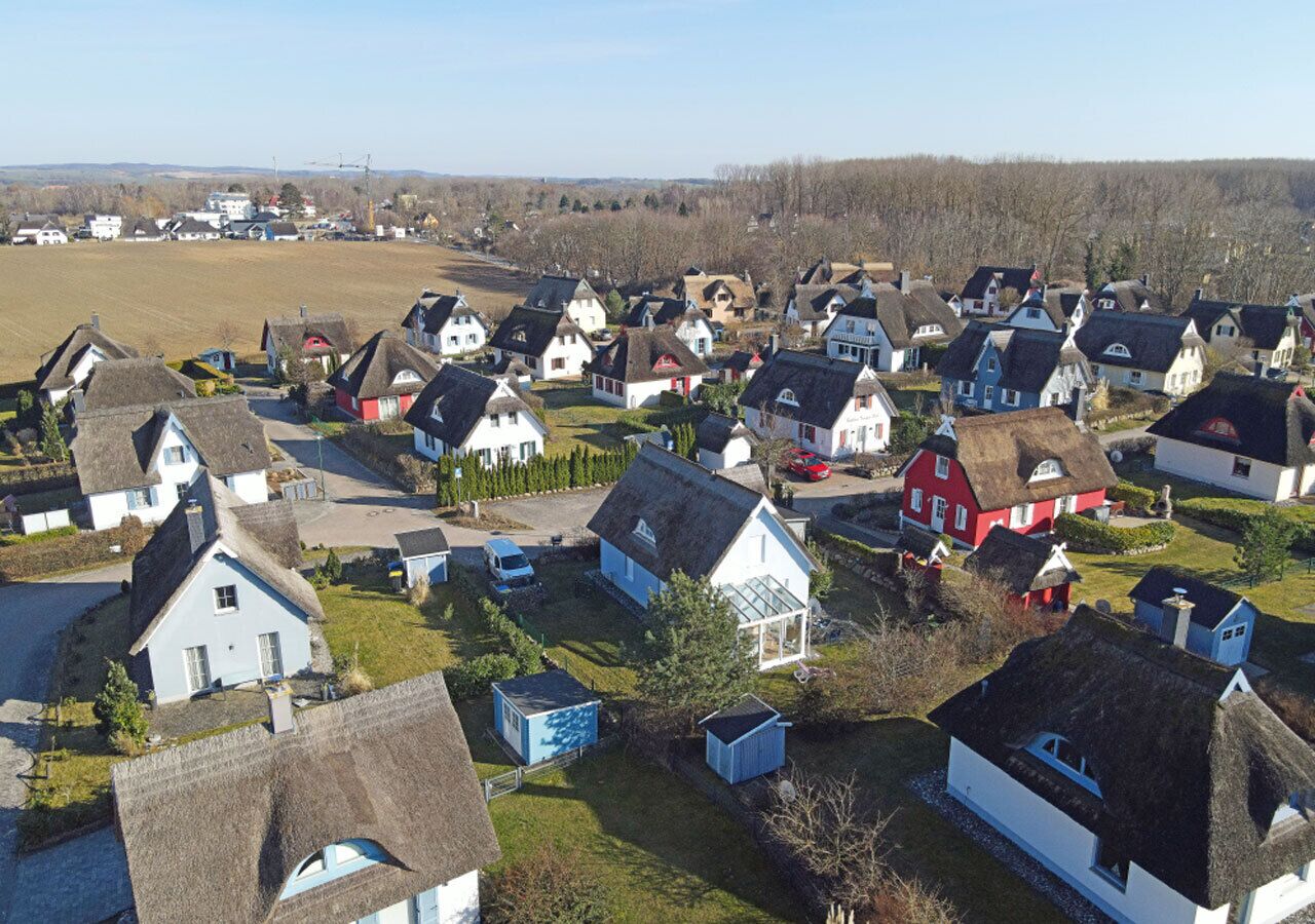 Un quartier résidentiel où l’on trouve des maisons dotées de toits de chaume et présentant un mélange de styles architecturaux.