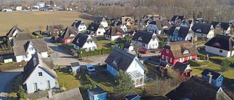 Un quartier résidentiel où l’on trouve des maisons dotées de toits de chaume et présentant un mélange de styles architecturaux.