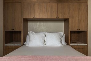 A bedroom with a bed, two nightstands, and wooden cabinetry. - Rattlesnake Ranch - Hollywood Retreat w Pool&Views (Yucca Valley)