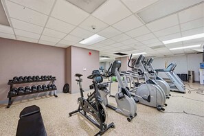 A gym with exercise equipment including dumbbells, a stationary bike, and treadmills. - Modern Loft Living in Downtown Detroit (Detroit)