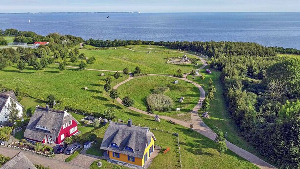 A coastal property with a grassy field, a walking path, and a view of the sea. - Vacation home with a fireplace and an infrared sauna, about 200 meters from the sandy beach (Glowe)