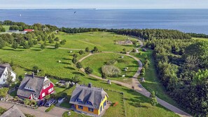 A coastal property with a grassy field, a walking path, and a view of the sea. - Vacation home with a fireplace and an infrared sauna, about 200 meters from the sandy beach (Glowe)