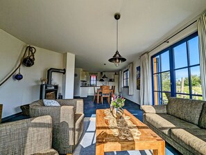 Ein geräumiges Wohnzimmer mit Kamin, Essbereich und großen Fenstern.