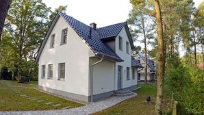 A modern two-story house with a sloped roof, a paved driveway, and a well-maintained lawn. - Vacation home with a fireplace and sauna, about 250 meters from the sandy beach, Wi-Fi, washing machine (Glowe)