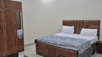 Un dormitorio con cama, armario y mesita de noche.