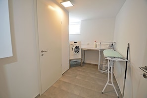 A laundry room with a washing machine, drying rack, and ironing station. - 2-story vacation home, quiet location, about 1.3 kilometers from the sandy beach (Baltic Sea) (Glowe)