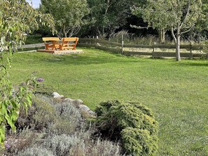A grassy outdoor area with a wooden bench and a wooden fence. - Two-story vacation home with 3 bedrooms and a fireplace, about 350 meters from the sandy beach (Glowe)