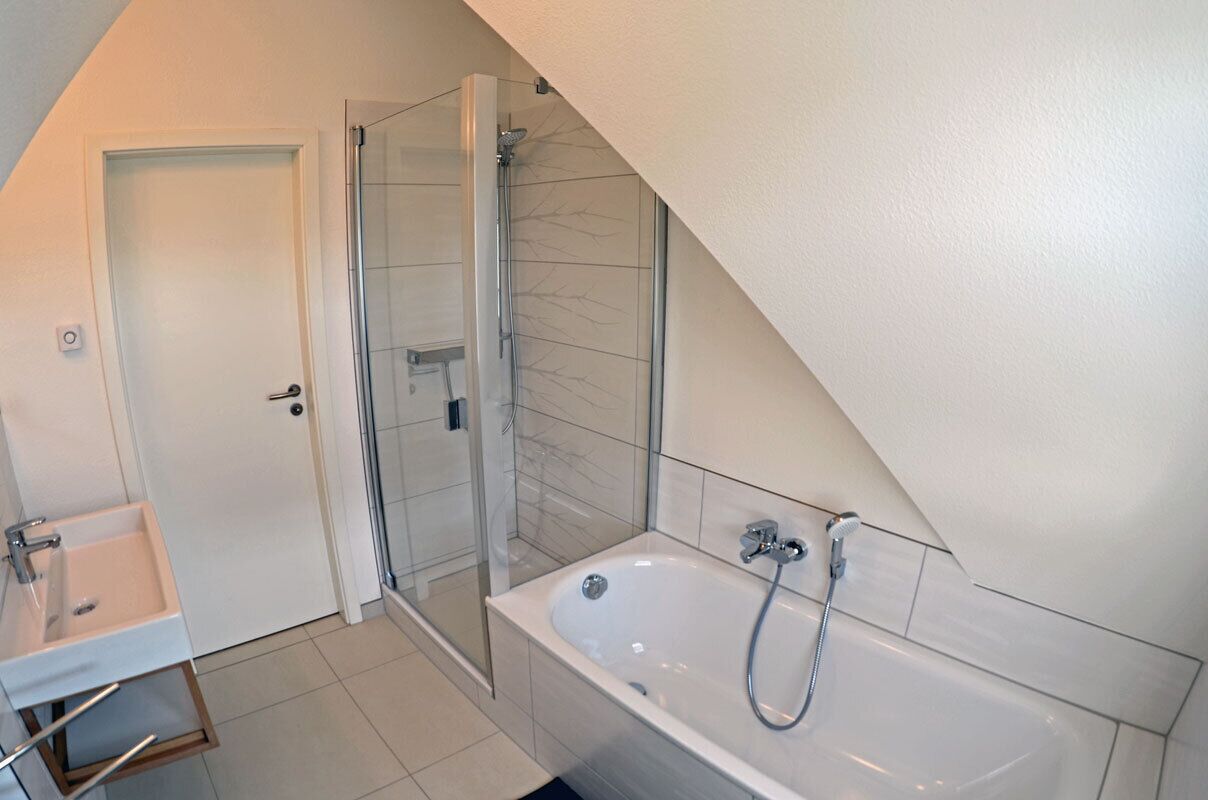Un baño moderno con ducha, bañera y lavamanos.