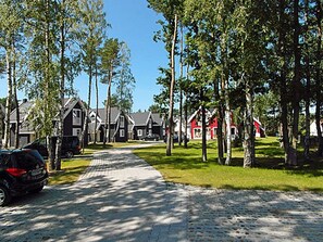 A cobblestone street lined with traditional houses, a parked car, and trees. - Vacation home with a fireplace, about 800 meters from the sandy beach, Wi-Fi, dogs welcome (Glowe)