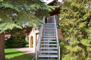 A metal staircase leading to a building with a brick facade and a red roof. - Just 250 meters from the sandy Baltic Sea beach, Wi-Fi, accommodates up to 4 people, with a covered patio (Glowe)