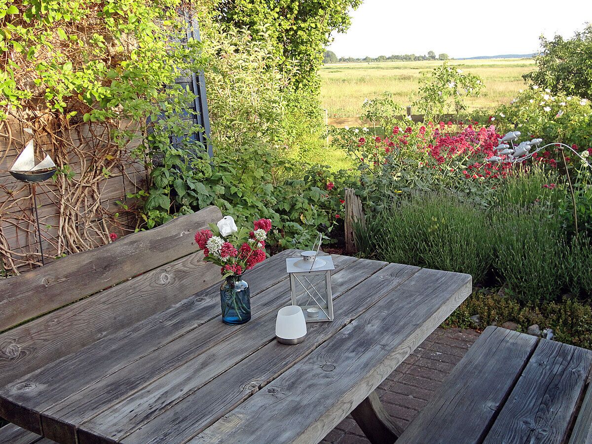A wooden table with a vase of flowers and two candle holders.
