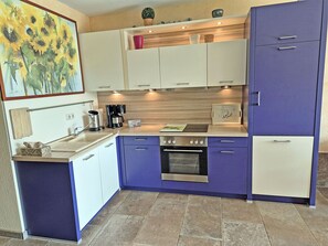 A compact kitchen with a built-in oven, a coffee maker, and a sink. - Vacation rental, very quiet location, about 350 m from the sandy beach (Baltic Sea), Wi-Fi (Glowe)