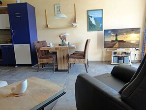 A compact living space with a dining area, a sofa, and a television. - Vacation rental, very quiet location, about 350 m from the sandy beach (Baltic Sea), Wi-Fi (Glowe)