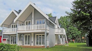 A two-story house with a balcony, a front porch, and a visible staircase leading to the upper floor. - Just 400 meters from the sandy Baltic Sea beach, Wi-Fi, and a washing machine with a covered patio (Glowe)