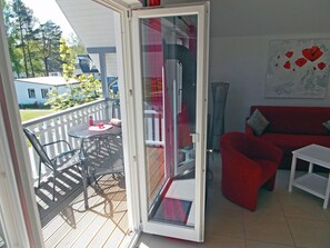A room with a sliding glass door leading to an outdoor patio with a table and chairs. - Just 500 meters from the sandy Baltic Sea beach, Wi-Fi, and a washing machine with a covered balcony (Glowe)