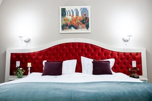 A bed with a red headboard, white bedding, and a painting above. - Grand Hotel Traian (Iași)