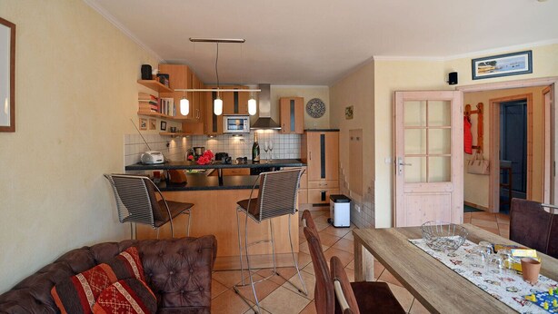 A compact living space with a kitchenette, a dining area with a table and chairs, and a sofa. - About 50 meters to the sandy beach and the boardwalk, Wi-Fi, washing machine, about 300 meters to the harbor (Glowe)