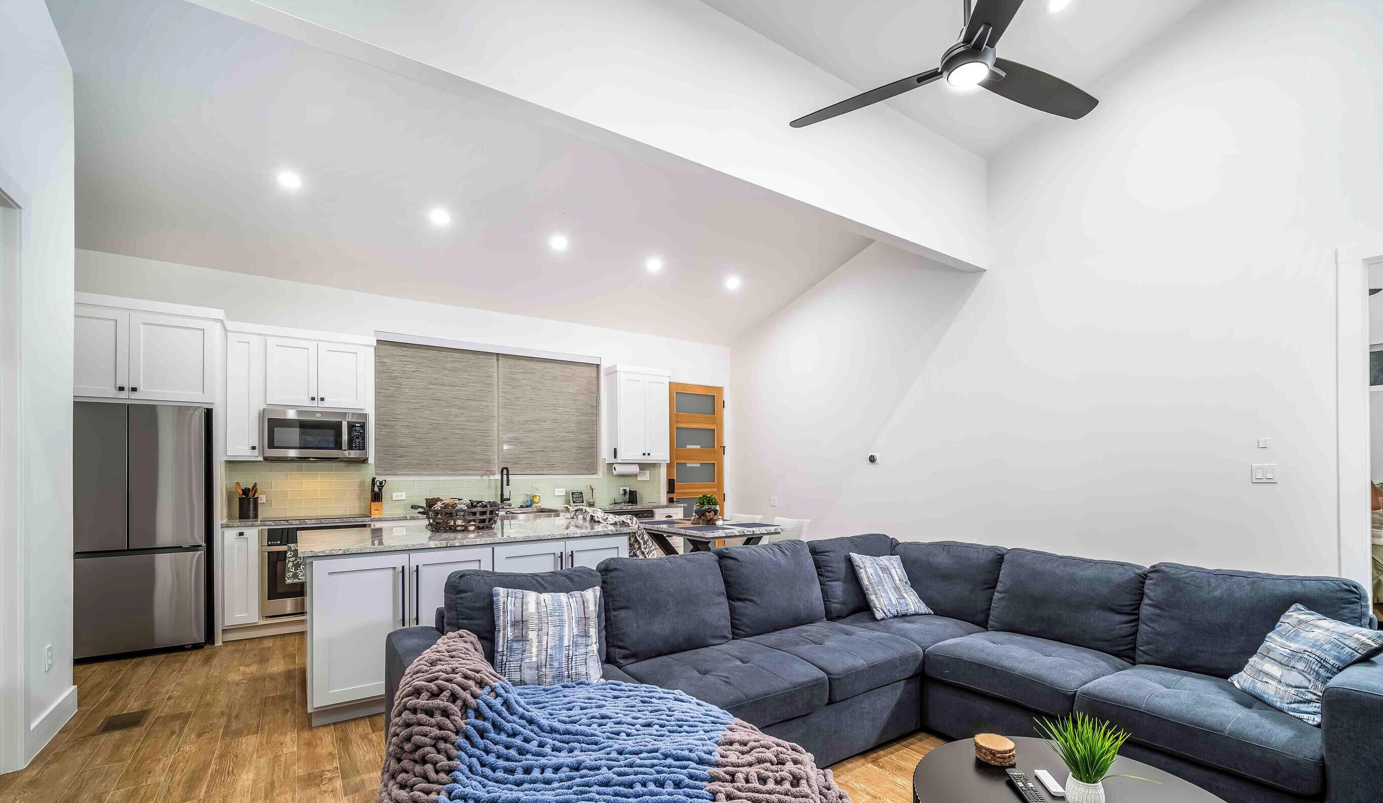 A modern kitchen with white cabinets, a stainless steel refrigerator, and a microwave.