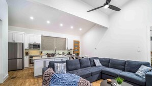 A modern kitchen with white cabinets, a stainless steel refrigerator, and a microwave. - Gettin' Woodsy and Cutesy by Lake Travis (Lago Vista)
