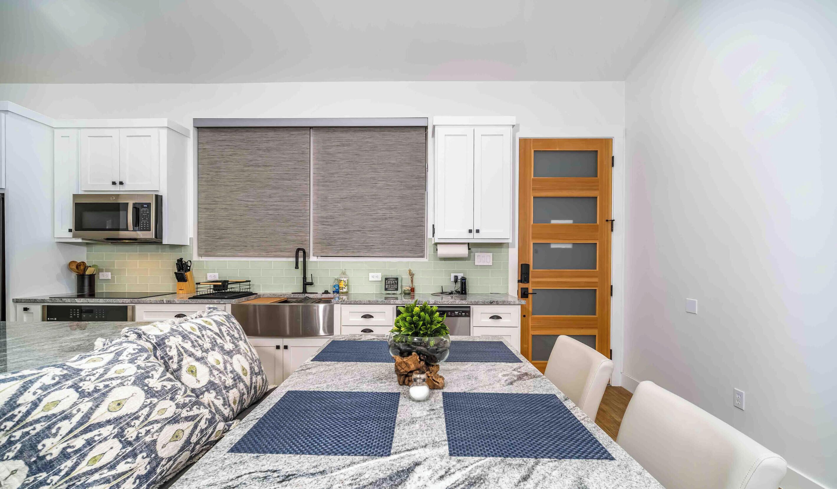 A compact kitchen with white cabinets, a microwave, and a sink.