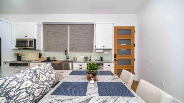A compact kitchen with white cabinets, a microwave, and a sink. - Gettin' Woodsy and Cutesy by Lake Travis (Lago Vista)