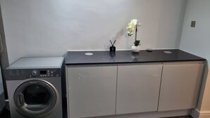 Uma área de lavanderia compacta com máquina de lavar e armários.