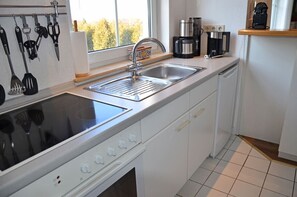 A kitchen with a built-in stove, a sink, and a coffee maker. - Tastefully decorated, 1st floor, Wi-Fi, washer and dryer, 900m from the beach (Breege)