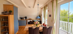 A kitchen with a dining area, a view of greenery outside, and a hanging light fixture. - Just 900 meters from the beach, with a balcony, internet/Wi-Fi, and a washing machine (Breege)