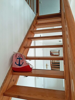 Eine hölzerne Treppe, an deren Seite eine Tasche hängt.