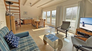 A living room with a sofa, coffee table, TV, and dining area with chairs and a table. - Only 900 meters from the beach, 1st floor with balcony, Internet/Wi-Fi, washing machine (Breege)