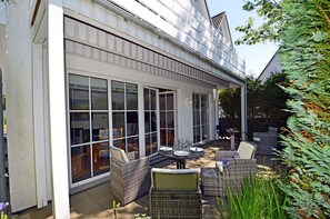 Un patio couvert aménagé avec du mobilier d’extérieur et une table à manger.