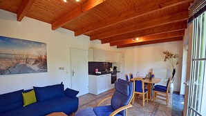Un espacio habitable compacto con kitchenette, comedor y zona de estar.