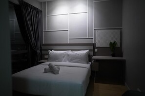 A hotel room with a bed, a nightstand, a potted plant, and a wall-mounted panel. - Datum Jelatek Residence  (Wilayah Persekutuan)