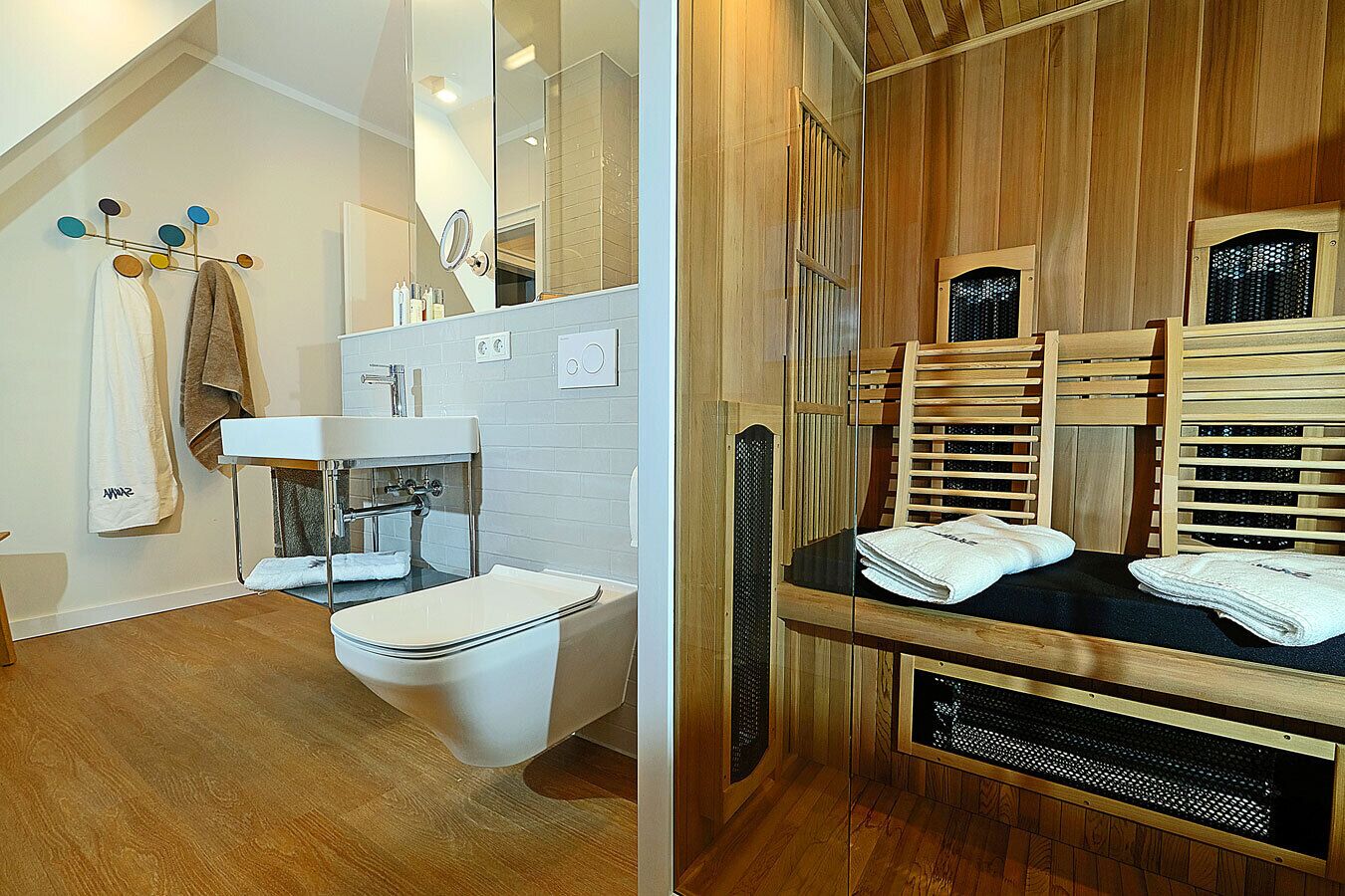 Une salle de bain moderne avec des toilettes, un lavabo et un espace de baignade en bois.