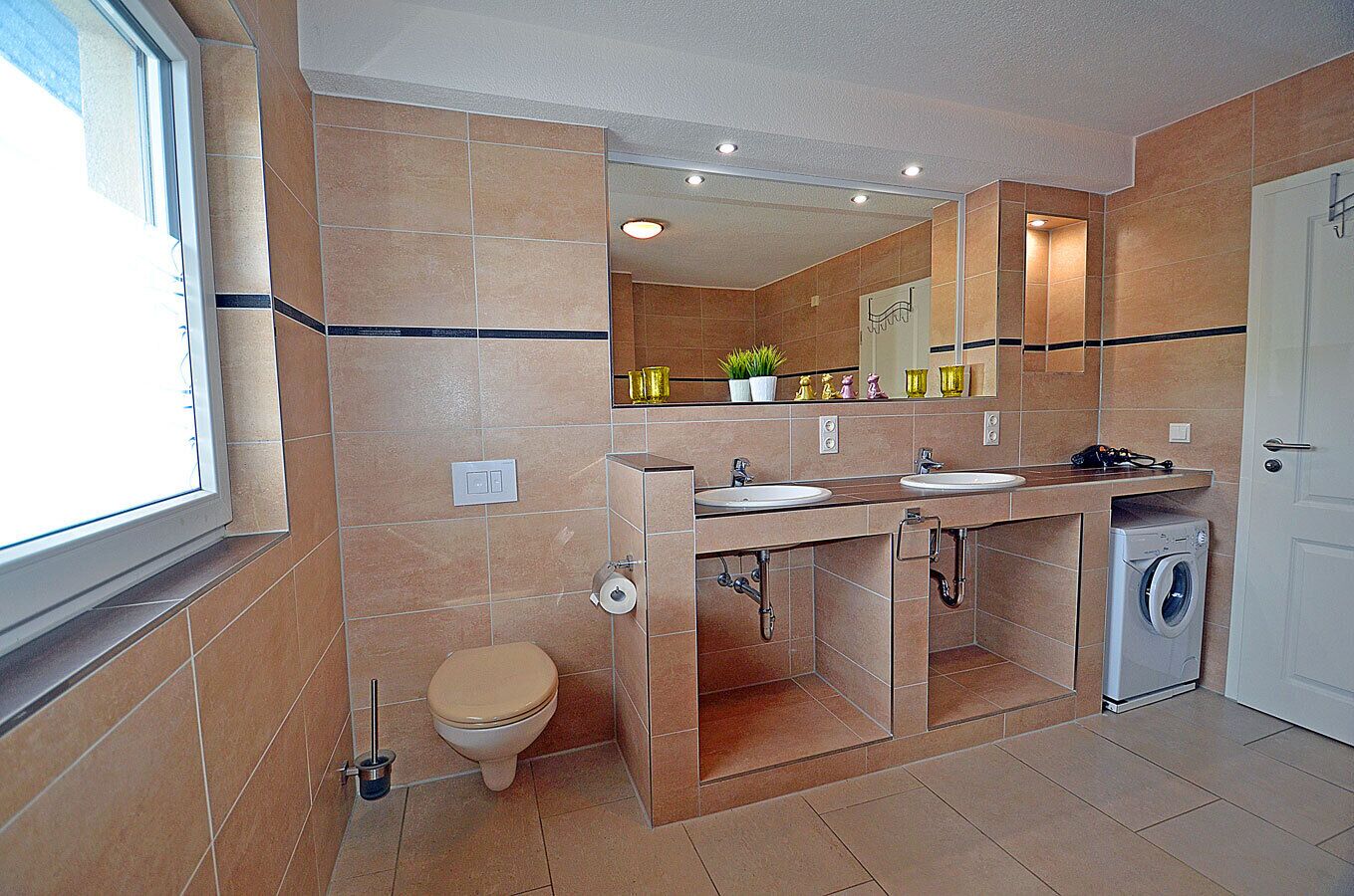 A bathroom with a toilet, sink, and washing machine.