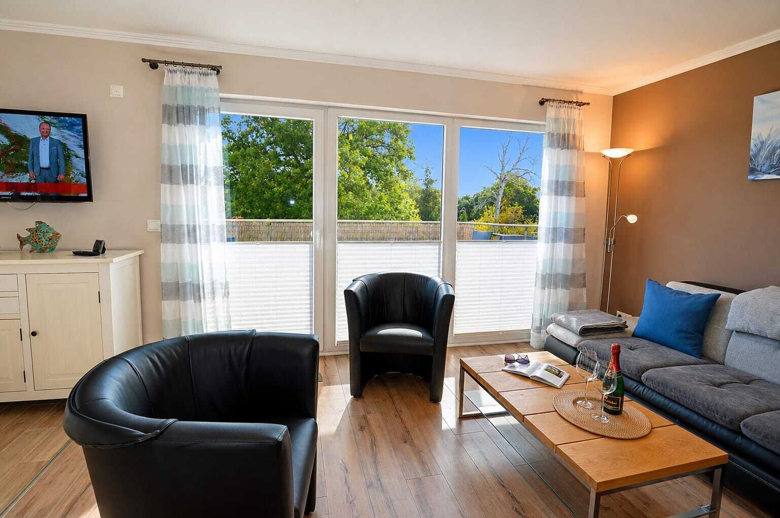A living room with a sofa, a chair, a coffee table, and a television.