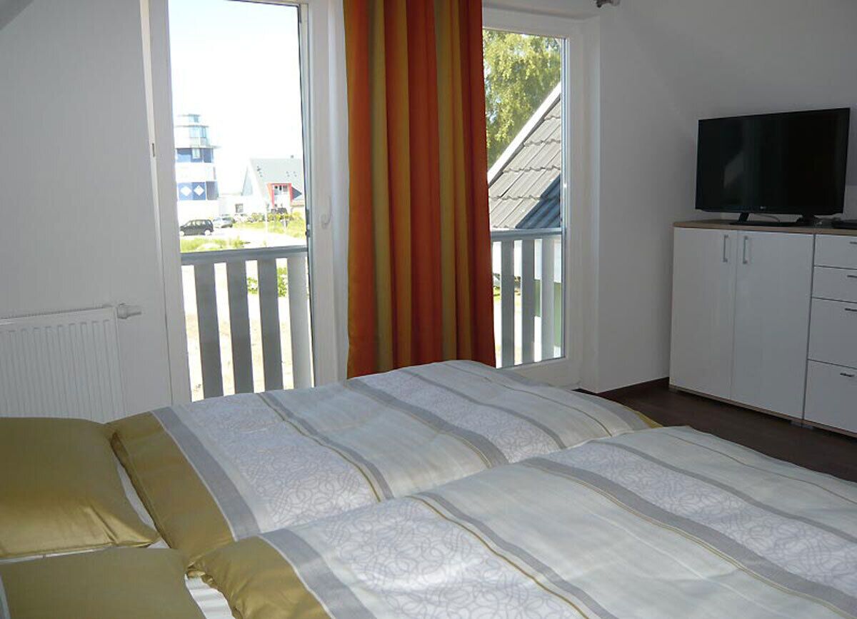 Une chambre à coucher avec un lit, une télévision et une vue sur l’extérieur.