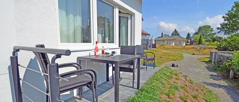 A patio with outdoor furniture, a table, and chairs.