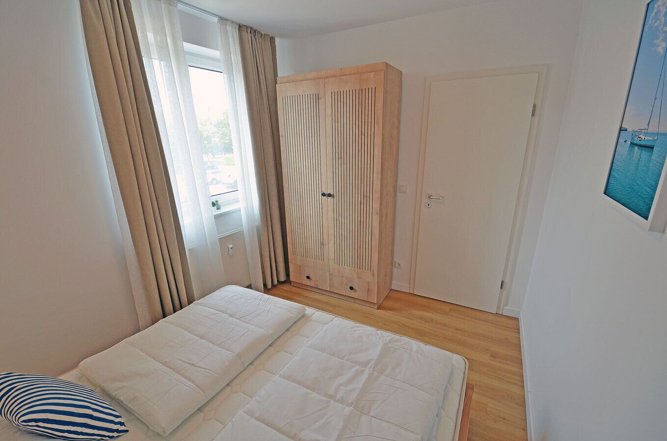 A bedroom with a bed, a wardrobe, and a door.