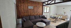 A living room with a sofa, a round coffee table, and a wooden wall with a framed photo.